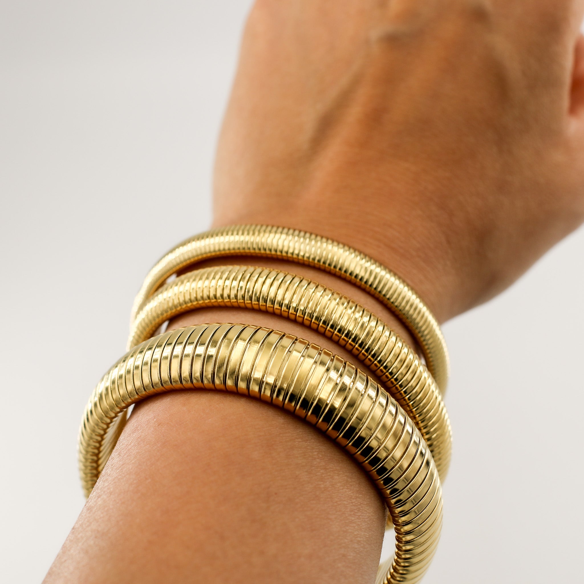 Drei Größen des Riviera Flex Armreifs in Gold und Silber, minimalistisch