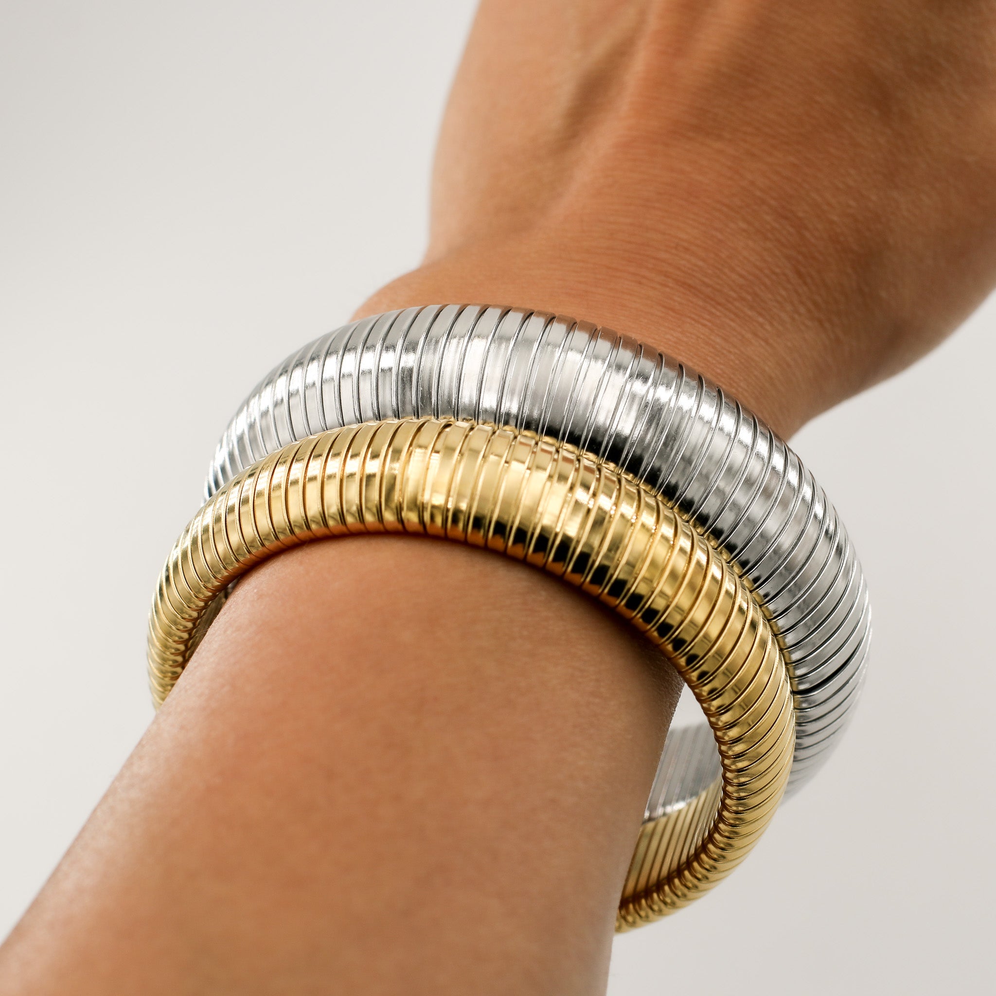 Drei Größen des Riviera Flex Armreifs in Gold und Silber, minimalistisch