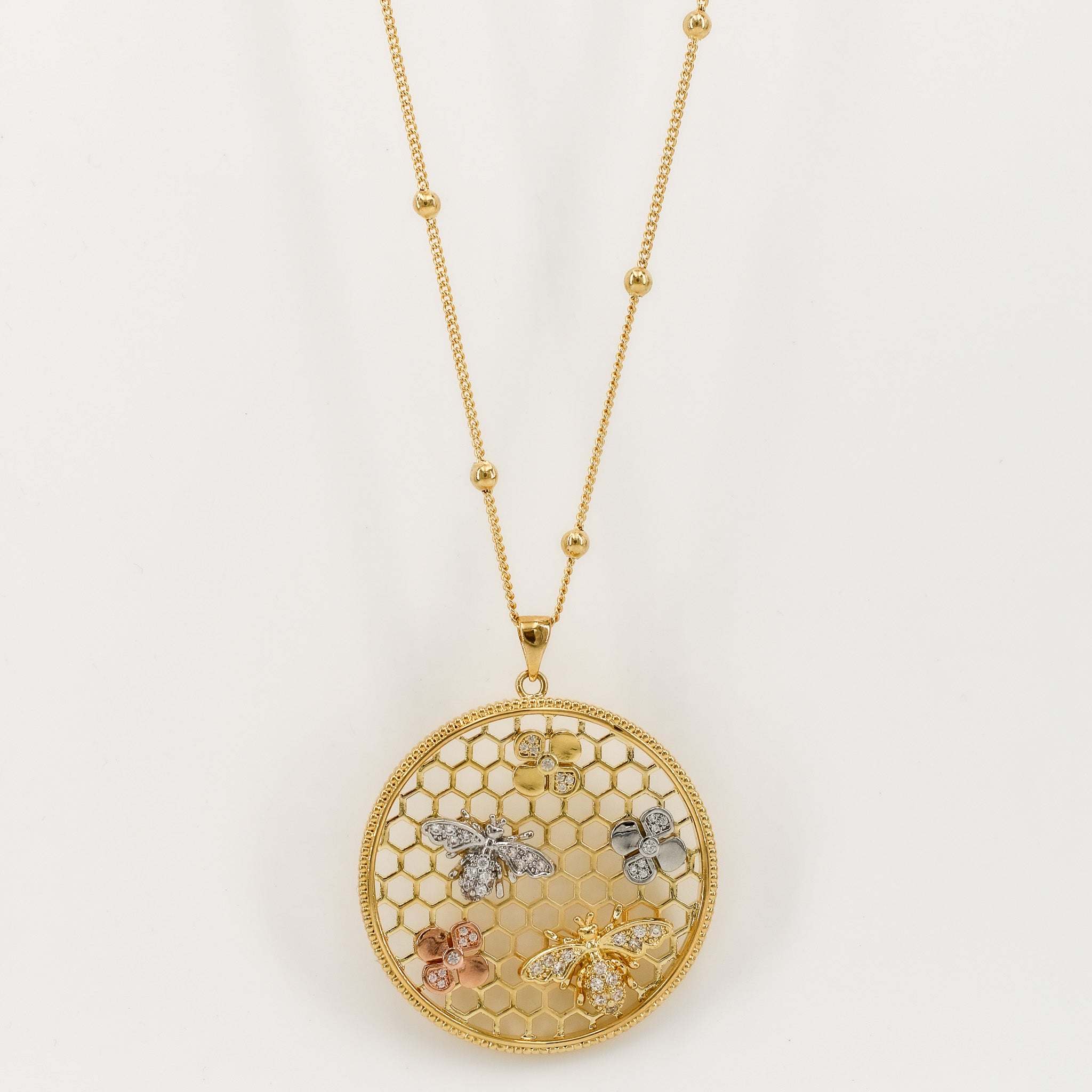 Die Assal Kette vereint modernes Design und natürliche Eleganz. Der goldene Anhänger im Bienenwaben-Stil ist mit filigranen Blumen- und Bienenmotiven verziert, die jedem Look das gewisse Etwas verleihen. Perfekt für besondere Anlässe oder den Alltag.