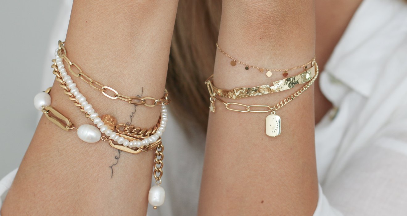 Verschiedene Armbänder an der Handgelenk des Models, von Perlen elegante Armband, bis zierliche Plättchen Armband, Armreif. 
