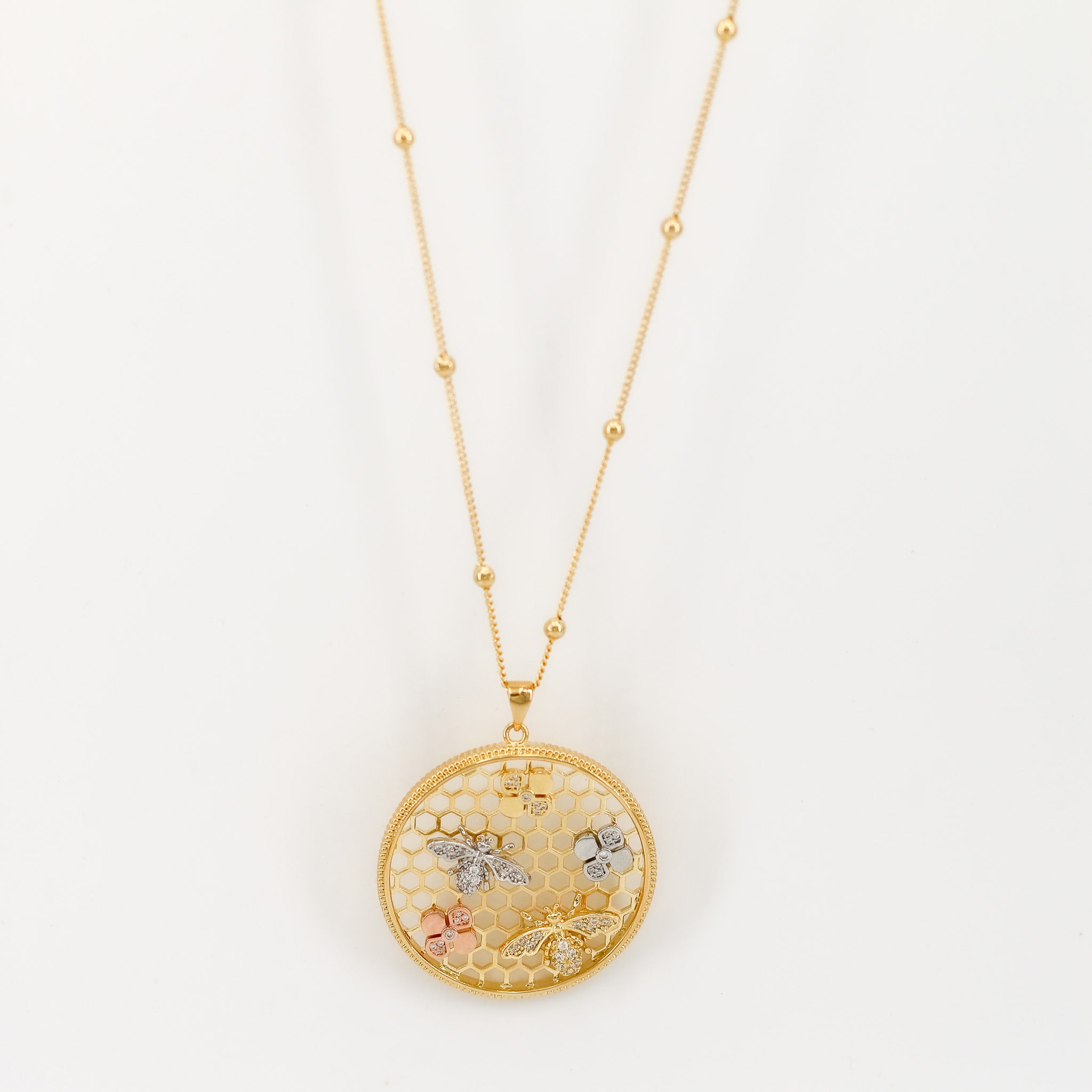 Die Assal Kette vereint modernes Design und natürliche Eleganz. Der goldene Anhänger im Bienenwaben-Stil ist mit filigranen Blumen- und Bienenmotiven verziert, die jedem Look das gewisse Etwas verleihen. Perfekt für besondere Anlässe oder den Alltag.